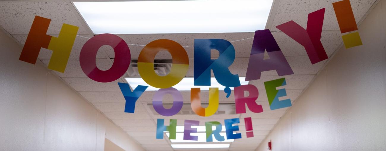 Banner in school hallway with letters spelling out Hooray You're Here!